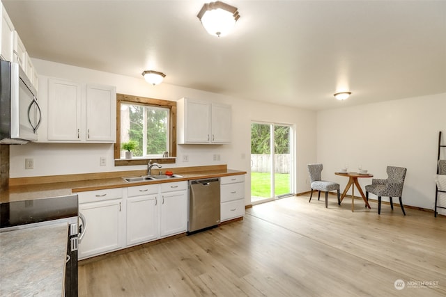 kitchen featuring a wealth of natural light, appliances with stainless steel finishes, and white cabinets