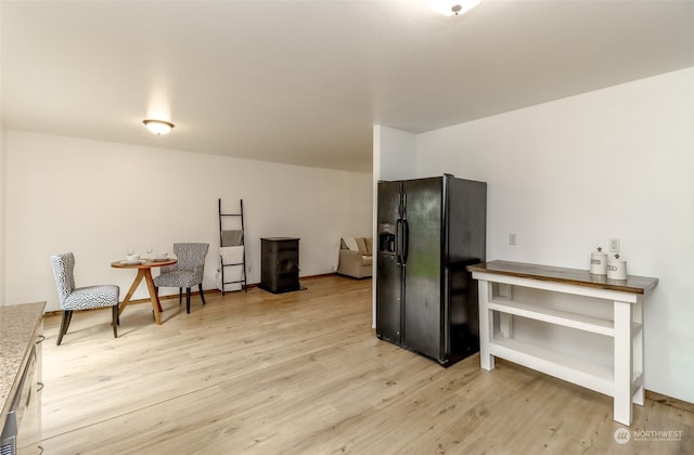 kitchen featuring black refrigerator with ice dispenser and light wood-type flooring