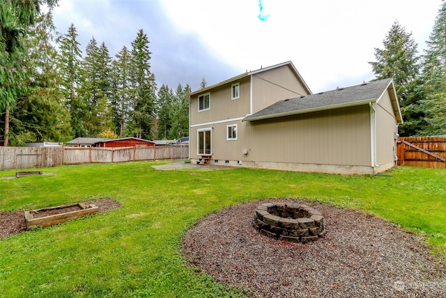 back of property featuring a yard and a fire pit