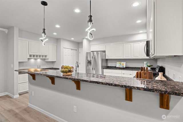 kitchen with white cabinetry, stainless steel appliances, and pendant lighting