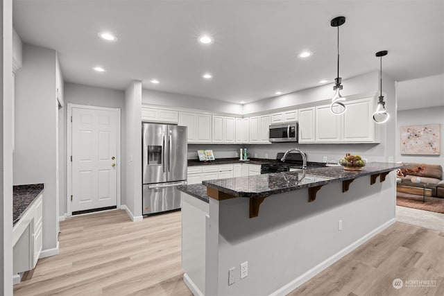 kitchen with white cabinetry, appliances with stainless steel finishes, and kitchen peninsula