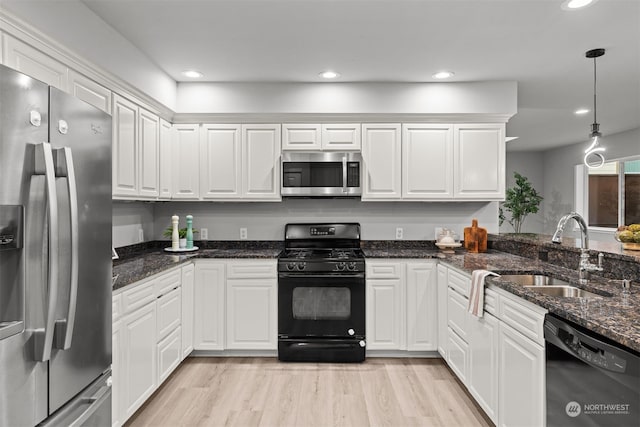 kitchen with sink, black appliances, white cabinets, and pendant lighting