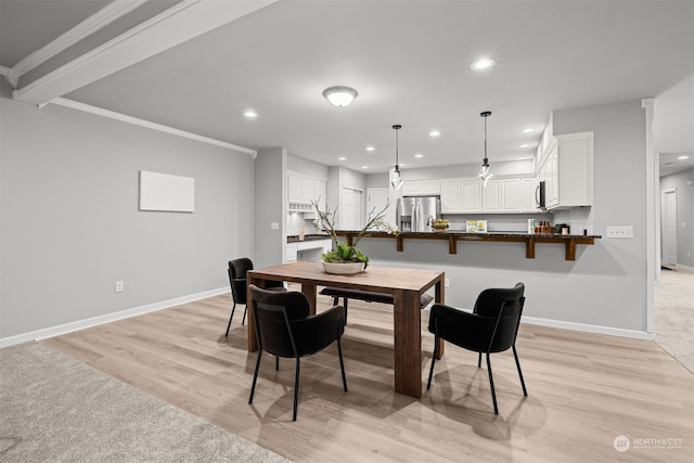 dining space with light hardwood / wood-style floors and crown molding