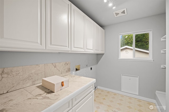 washroom with cabinets, hookup for a washing machine, and electric dryer hookup