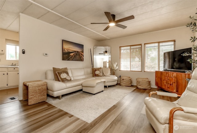 living room featuring ceiling fan, wood-type flooring, and sink