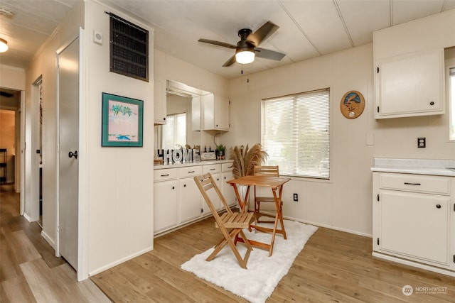 kitchen featuring white cabinets, light hardwood / wood-style flooring, and ceiling fan