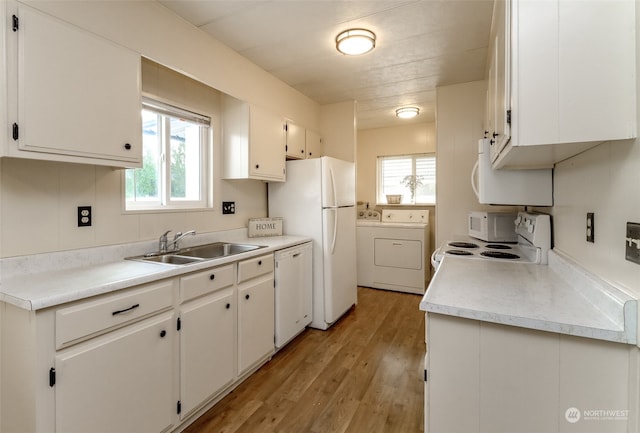 kitchen featuring white cabinetry, light hardwood / wood-style flooring, sink, washer and clothes dryer, and white appliances