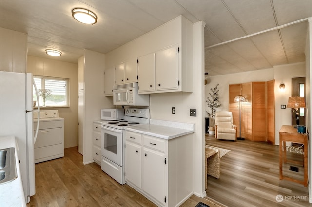 kitchen with washer / dryer, white cabinets, light wood-type flooring, and white appliances