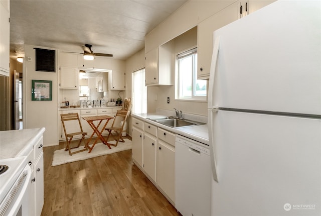 kitchen featuring sink, white cabinetry, light wood-type flooring, and white appliances