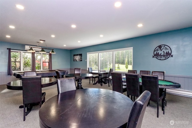 carpeted dining room with an AC wall unit and wooden walls