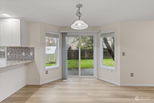 unfurnished dining area with light hardwood / wood-style floors