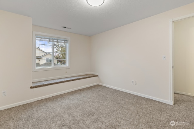 unfurnished room with a textured ceiling and carpet flooring