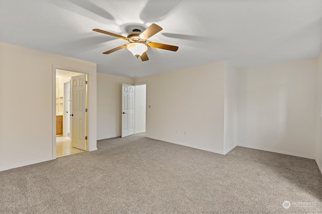 carpeted empty room with ceiling fan and a textured ceiling