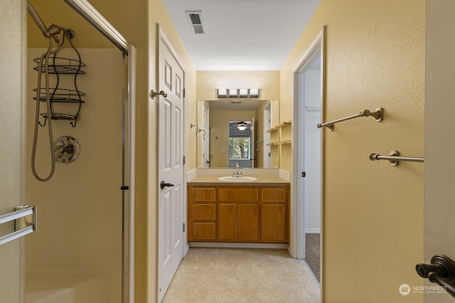 bathroom with a shower with door, vanity, and crown molding