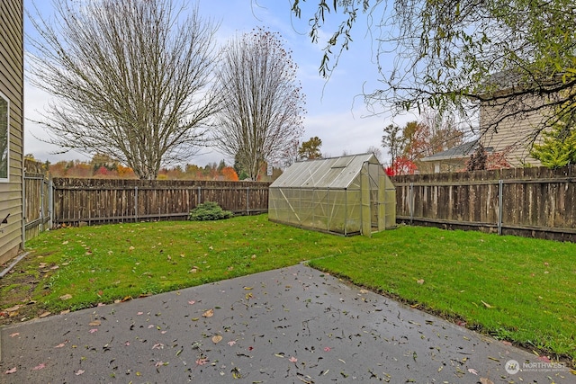 view of yard with a storage shed and a patio