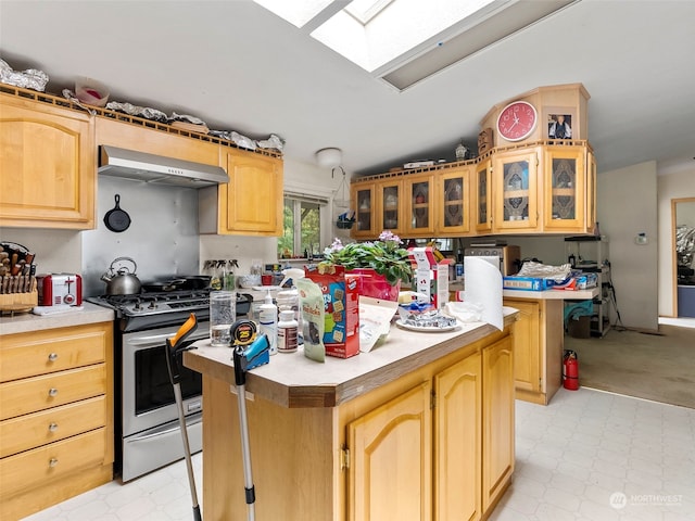 kitchen with gas stove, ventilation hood, a skylight, and a kitchen island