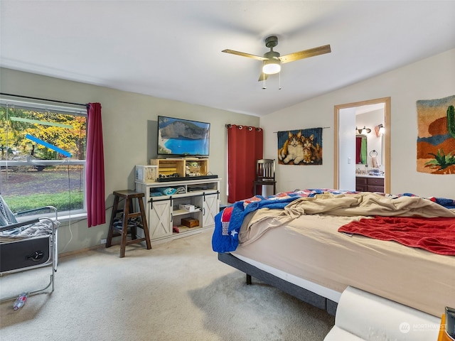 carpeted bedroom featuring connected bathroom, vaulted ceiling, and ceiling fan