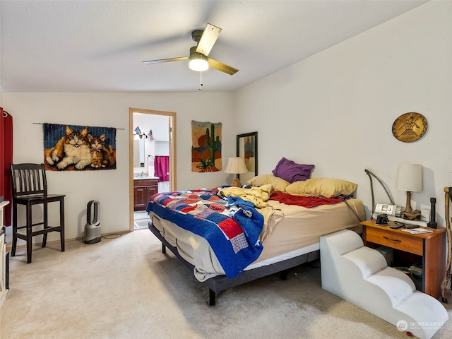 bedroom with ensuite bathroom, light carpet, lofted ceiling, and ceiling fan
