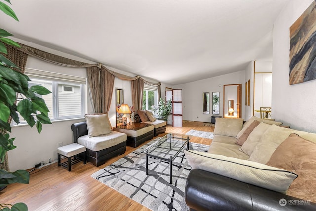 living room featuring light wood-type flooring and vaulted ceiling