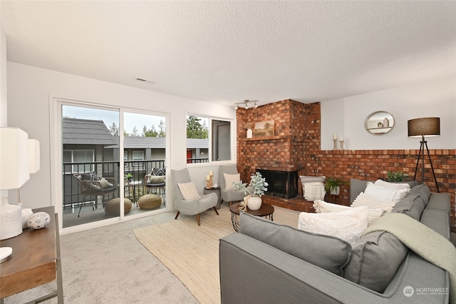 living room featuring a fireplace, carpet, a textured ceiling, and brick wall