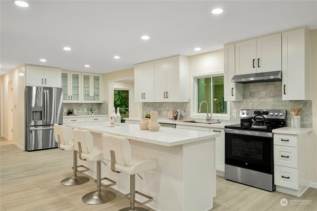 23405 NE 73rd St, Redmond, WA 98053 - kitchen with a kitchen island, stainless steel appliances, light hardwood / wood-style floors, and a breakfast bar