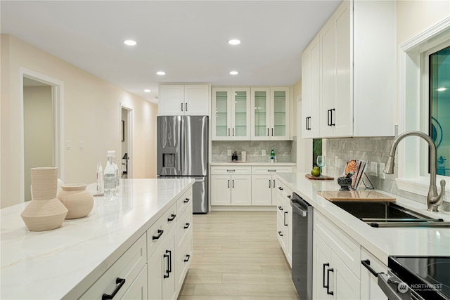 23405 NE 73rd St, Redmond, WA 98053 - kitchen featuring white cabinetry, light stone counters, stainless steel appliances, and sink