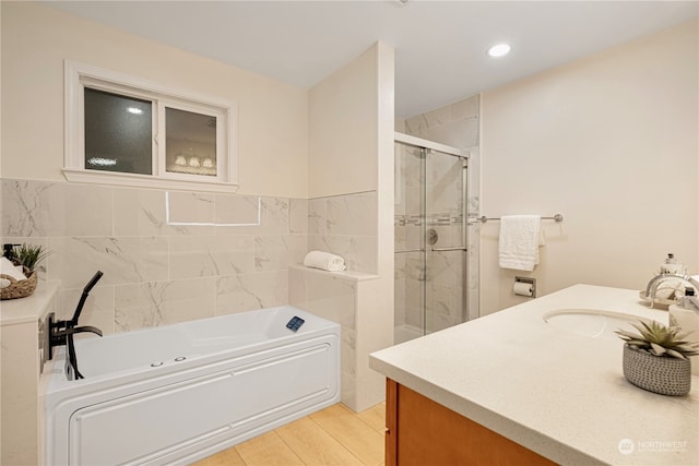 23405 NE 73rd St, Redmond, WA 98053 - bathroom featuring vanity, hardwood / wood-style flooring, tile walls, and shower with separate bathtub