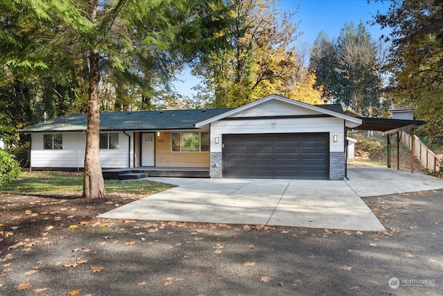 ranch-style house featuring a garage, covered porch, and a carport