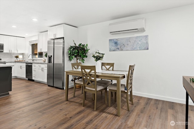 kitchen with white cabinetry, stainless steel appliances, dark wood-type flooring, and an AC wall unit