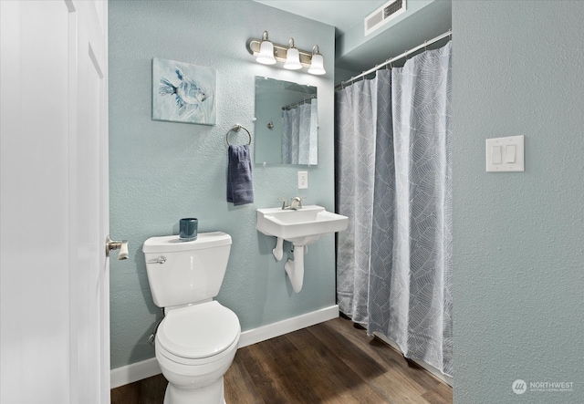 bathroom featuring toilet, sink, and hardwood / wood-style floors