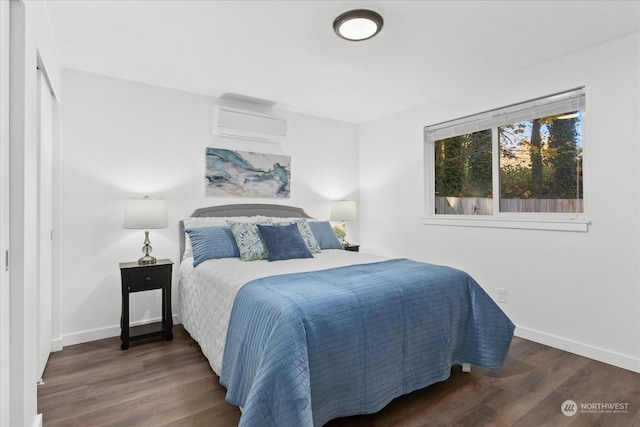 bedroom featuring a wall unit AC and dark wood-type flooring