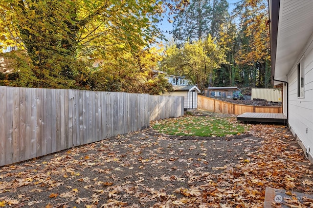 view of yard featuring a storage unit and a wooden deck