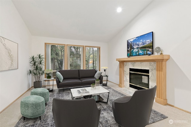 living room with a premium fireplace, vaulted ceiling, and carpet