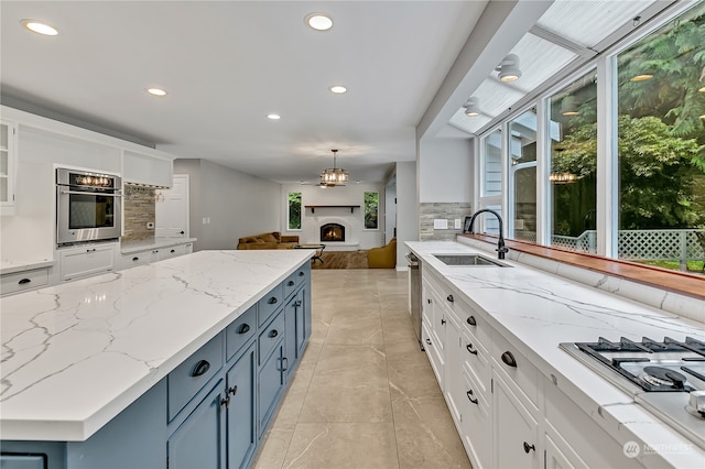 kitchen with blue cabinetry, white cabinets, and stainless steel appliances