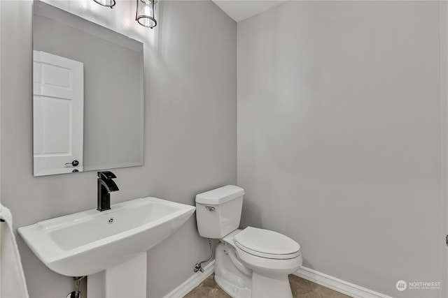 bathroom with sink, toilet, and tile patterned flooring