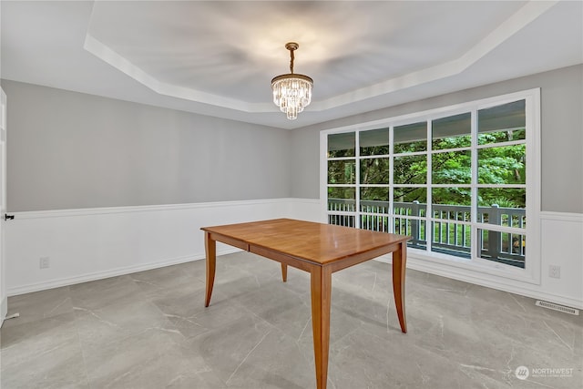 unfurnished office with an inviting chandelier and a tray ceiling