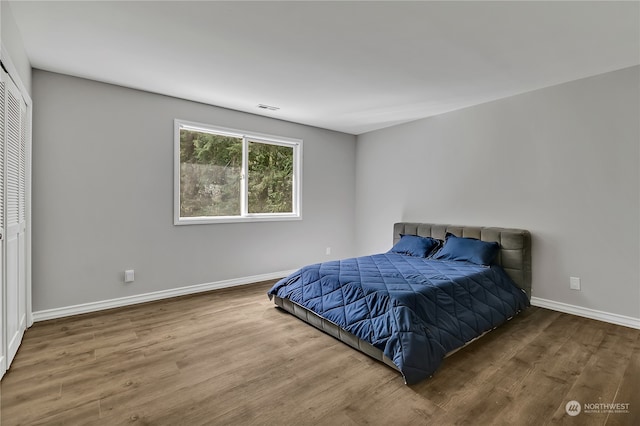 bedroom with wood-type flooring and a closet