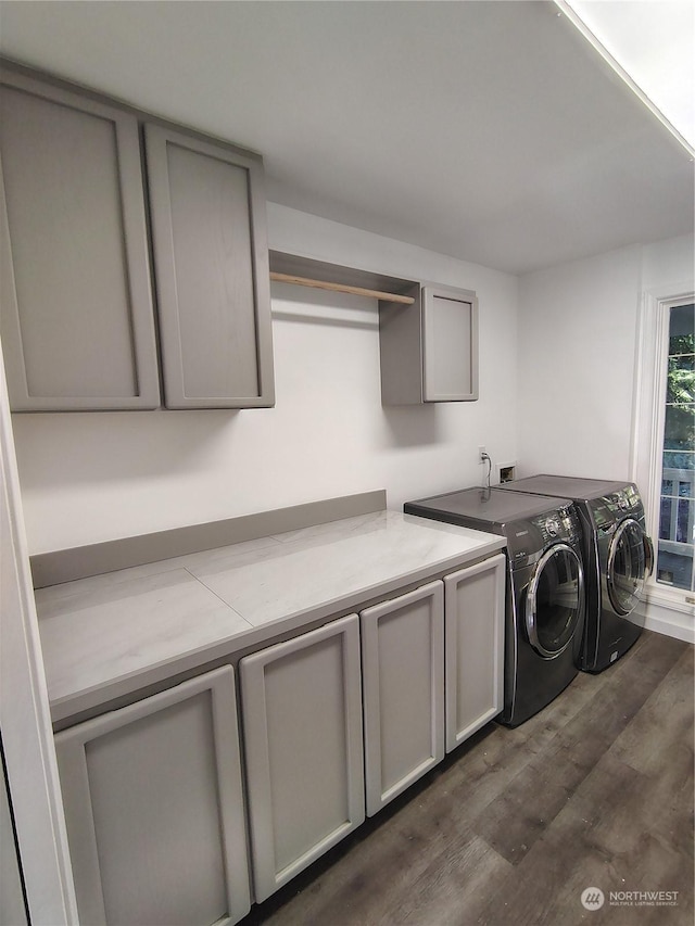 laundry area featuring dark wood-type flooring, cabinets, and independent washer and dryer