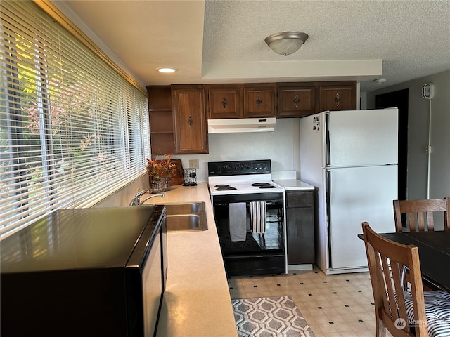 kitchen with white appliances, a textured ceiling, and sink