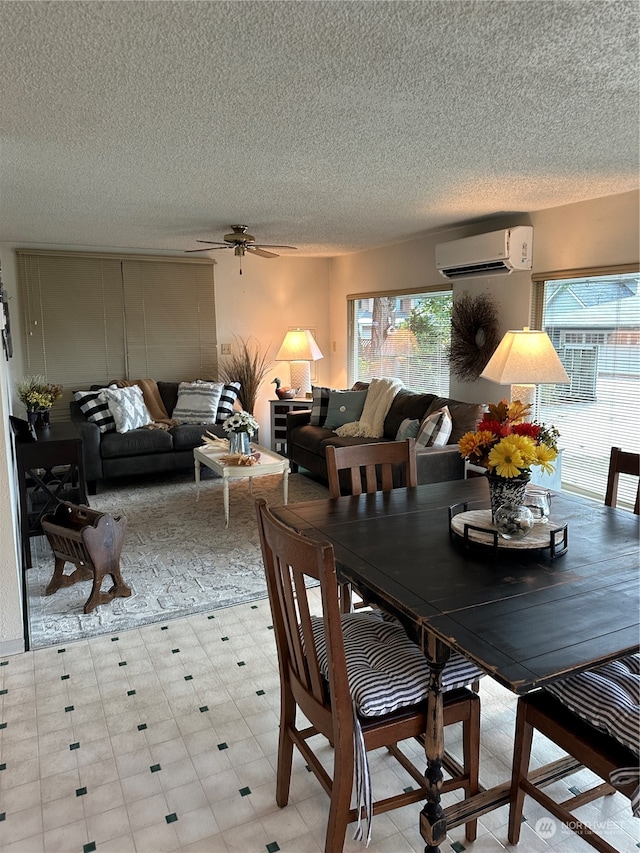 dining area featuring a textured ceiling, a wall mounted AC, and ceiling fan