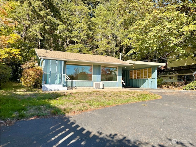 view of front of property with a sunroom and a carport