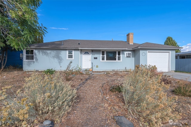 ranch-style house with a wall mounted AC and a garage