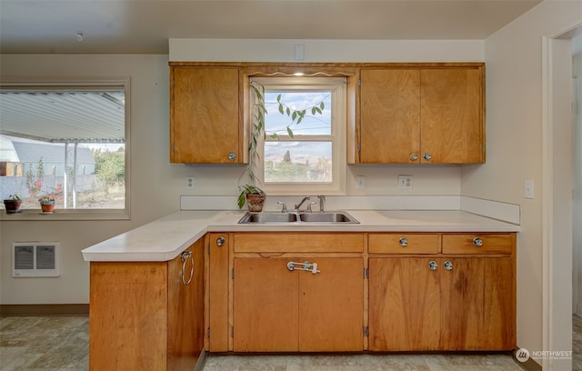 kitchen with kitchen peninsula, sink, and plenty of natural light