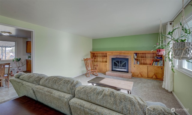 carpeted living room featuring a brick fireplace and plenty of natural light