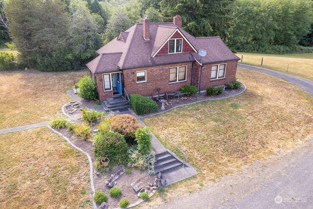 9346 Nels Nelson Rd NW, Bremerton, WA 98311 - view of front of home with brick siding, a chimney, a front lawn, and a view of trees
