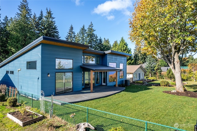 back of house featuring central air condition unit, a patio area, and a lawn