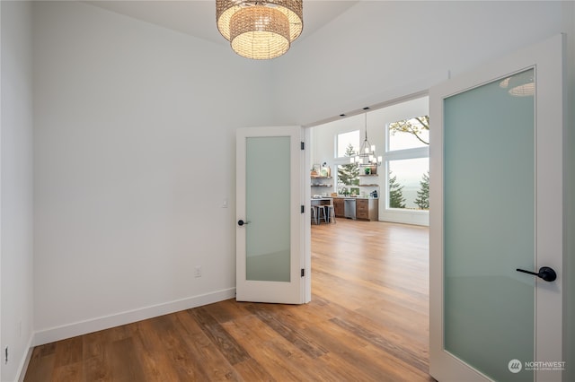 unfurnished room featuring hardwood / wood-style floors and an inviting chandelier