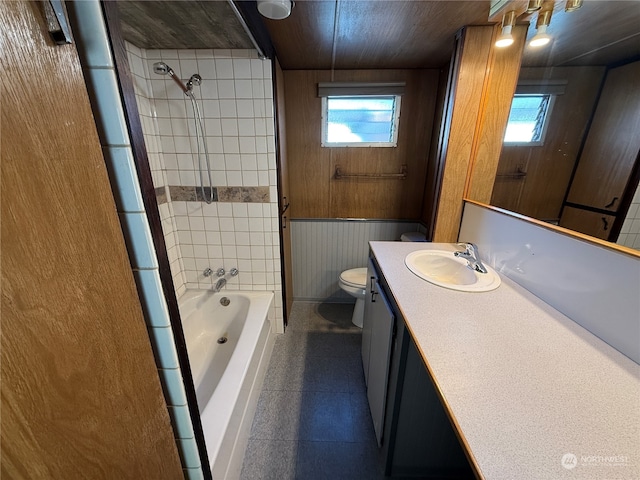 bathroom with vanity, wooden walls, and toilet