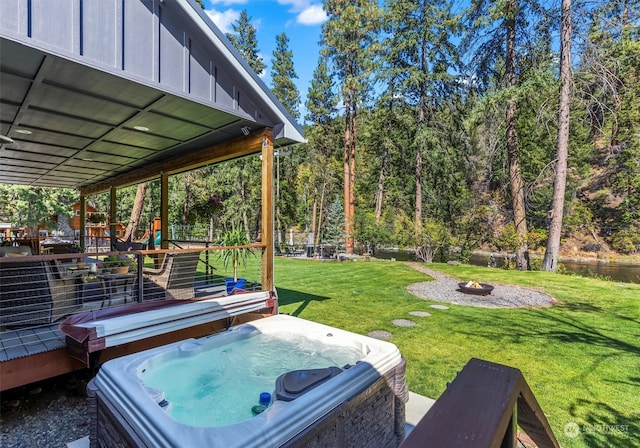 view of yard with a fire pit, a wooden deck, and a hot tub