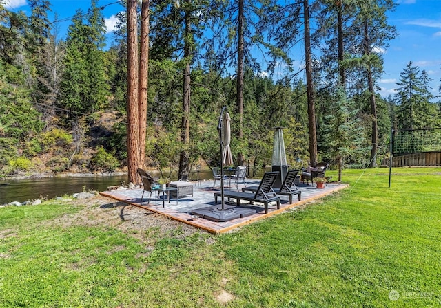 view of yard with a fire pit, a water view, and a patio